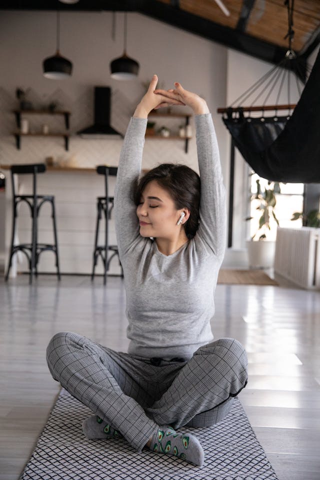 Woman doing yoga while stretching and practicing mindfulness.